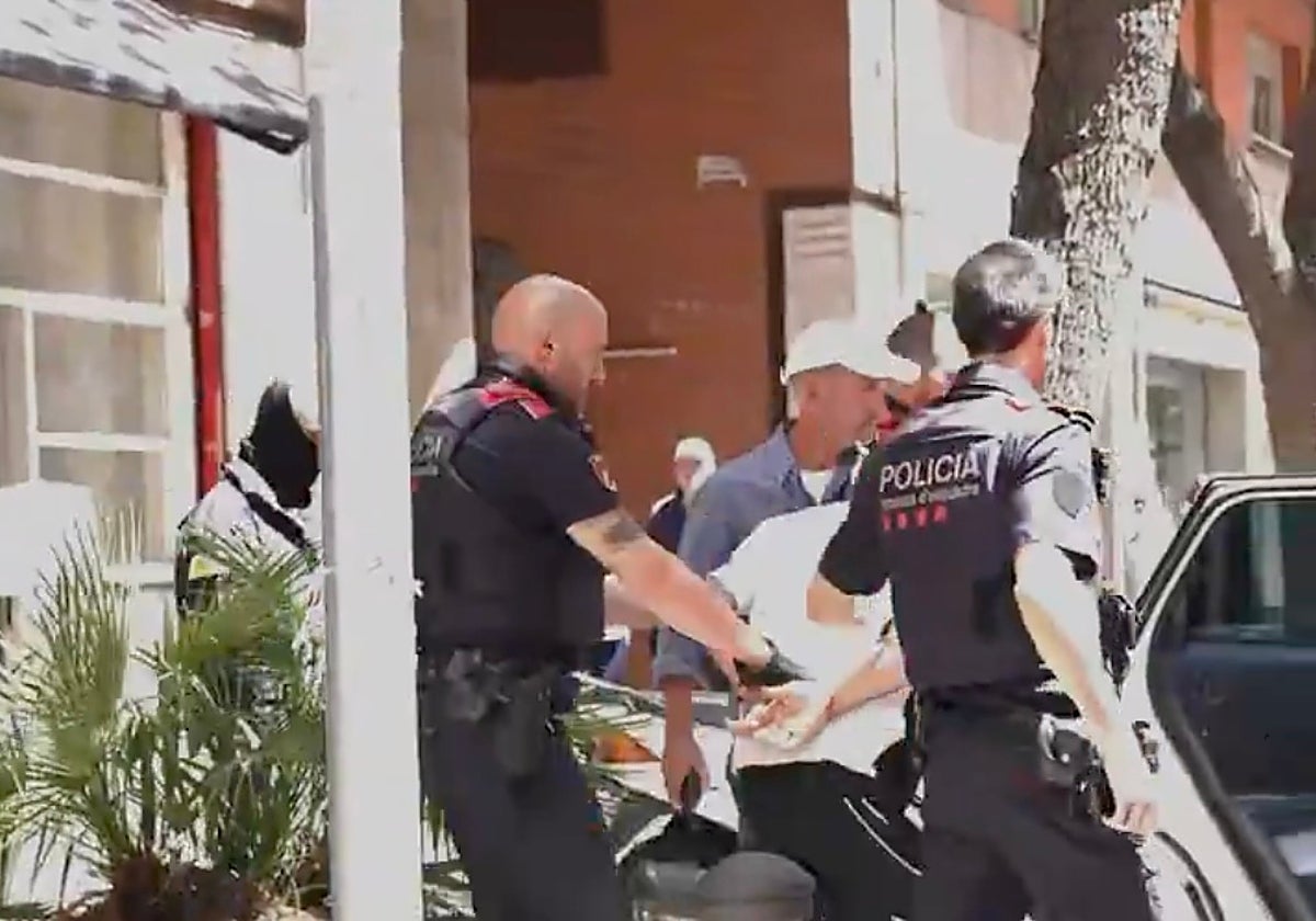Agentes de los Mossos, tras detener a uno de los atracadores, este viernes, en la zona alta de Barcelona