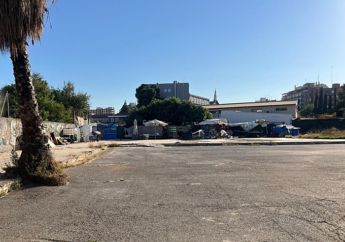 La parcela abandonada con varios asentamientos al fondo.