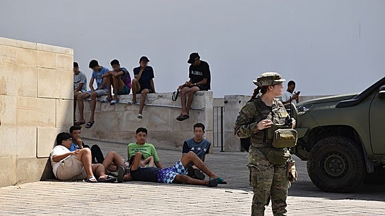 Menores no acompañados esperan sentados en Ceuta