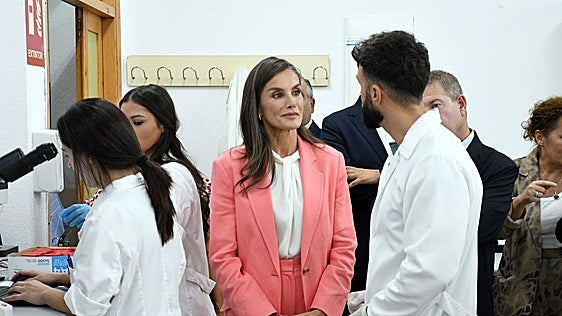 La reina conversa con un docente en uno de los laboratorios del centro educativo.