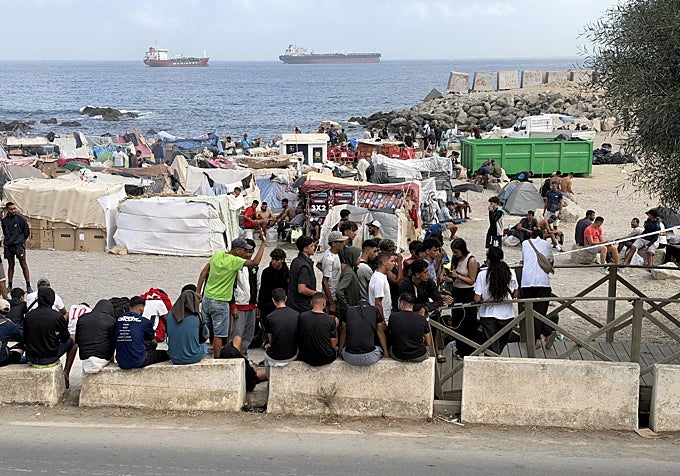 Decenas de inmigrantes esperan a la entrada del Trampolín a que la Policía levante un cordón de seguridad