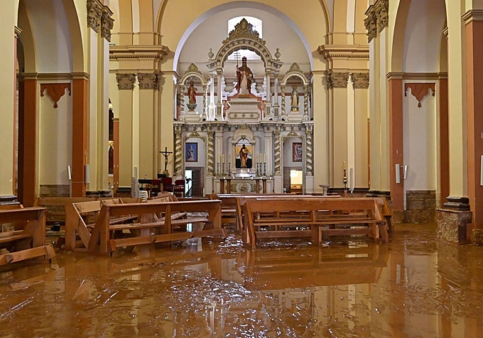 Bancos amontonados en la iglesia de Madrigueras tras las inundaciones.