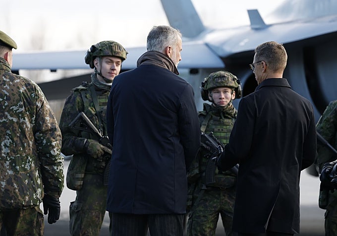 El Rey conversa con varios soldados ante un avión de combate durante la visita del monarca al Ala Aérea Lapland