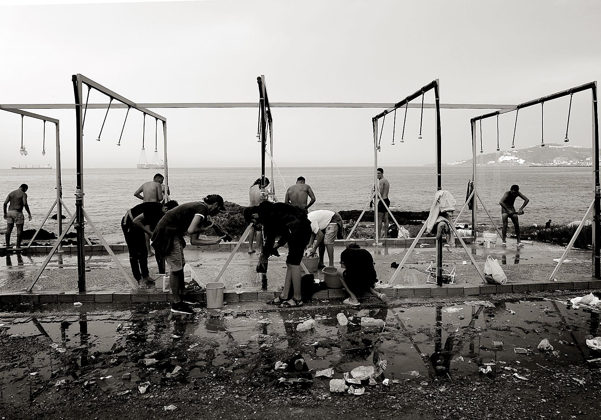 Un grupo de inmigrantes se ducha en la playa de El Guano