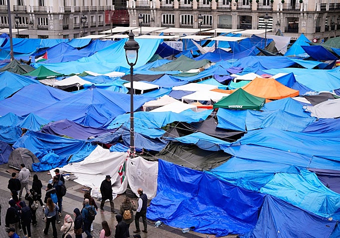 Los acampados en la Puerta del Sol, este domingo, bajo la lluvia.