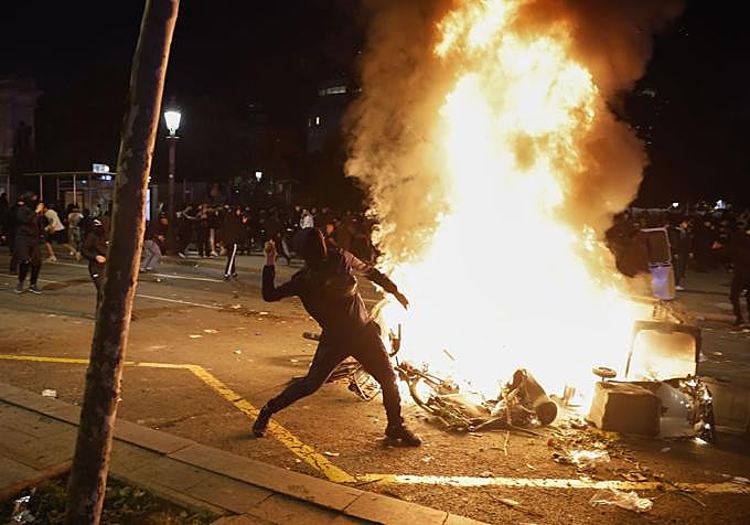 Un joven lanza una piedra contra los Mossos