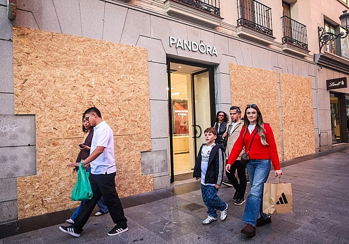 Comercio en la calle de Preciados tapia sus escaparates, este domingo.