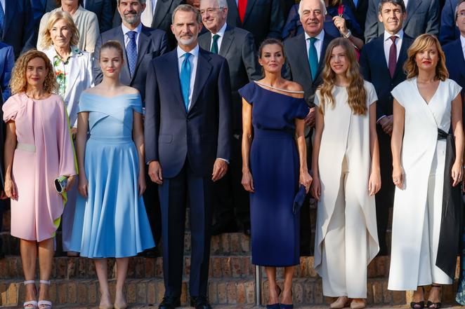 Vestidos y una casualidad. Mientras Doña Letizia y su hija Leonor escogieron modelos similares -vestidos azules de largo medio y hombros al descubierto- la infanta Sofía optó por un look rompedor con pantalón blanco y blusca con sobrecapa larga. Lo curioso es que tan singular modelo era muy similar a su compañera en las fotos.