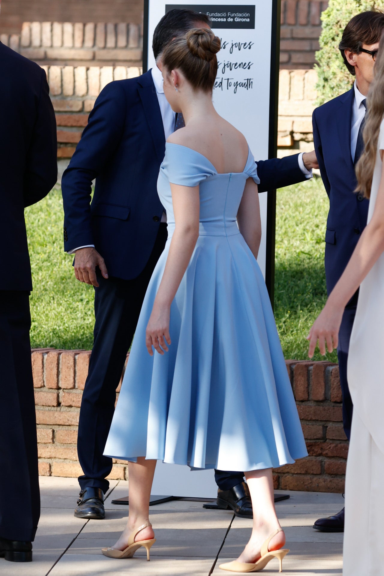 Leonor, muy elegante. Estos días la hemos visto con un vestido estampado en  flores rojas de Mango , y luego con otro  modelo camisero de Polin et Moi . En los premios Princesa de Girona, Leonor ha optado por la elegancia con un vestido azul cielo de falda acampanada, mangas caídas y gran escote barco. El pelo, recogido en un moño para lucir el atuendo en todo su esplendor. En los pies, un básico: salones 'nude' destalonados de taco medio. Doña Leonor dio, en el acto,  su tercer discurso en Cataluña .