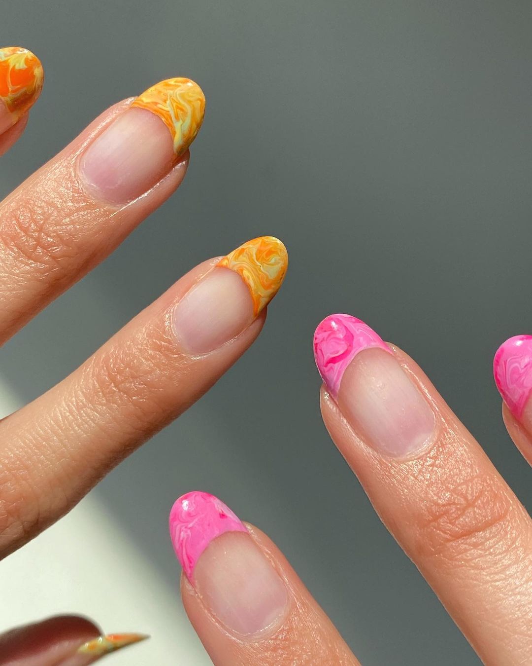 Manicura francesa con efecto mármol. En uñas largas, se puede jugar con diseños más sofisticados como esta manicura francesa con efecto mármol en tono rosa o naranja. 