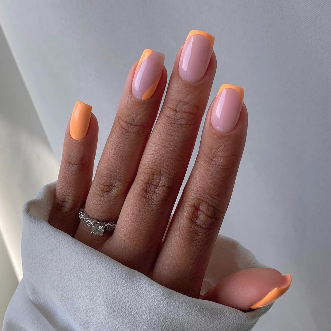 Manicura francesa naranja con uñas lisas. Otro diseño que queda muy bien es llevar la manicura francesa en dos o tres uñas y dejar las demás lisas en el mismo color con la parte superior o con algún diseño como unas ondas o unas líneas perpendiculares.