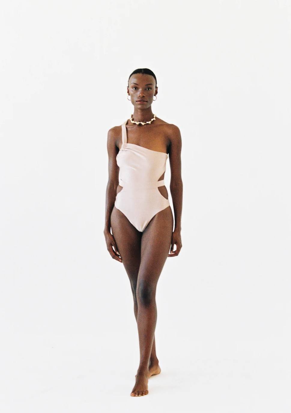 Bionda Swimwear fusiona dos de los elementos más buscados en los bañadores consiguiendo un modelo ideal y muy  favorecedor para la figura. Presenta un diseño 'cut-out' y un corte asimétrico que en tono arena invita a complementar con diversidad de accesorios haciéndolo una prenda versátil. Cuesta 145€