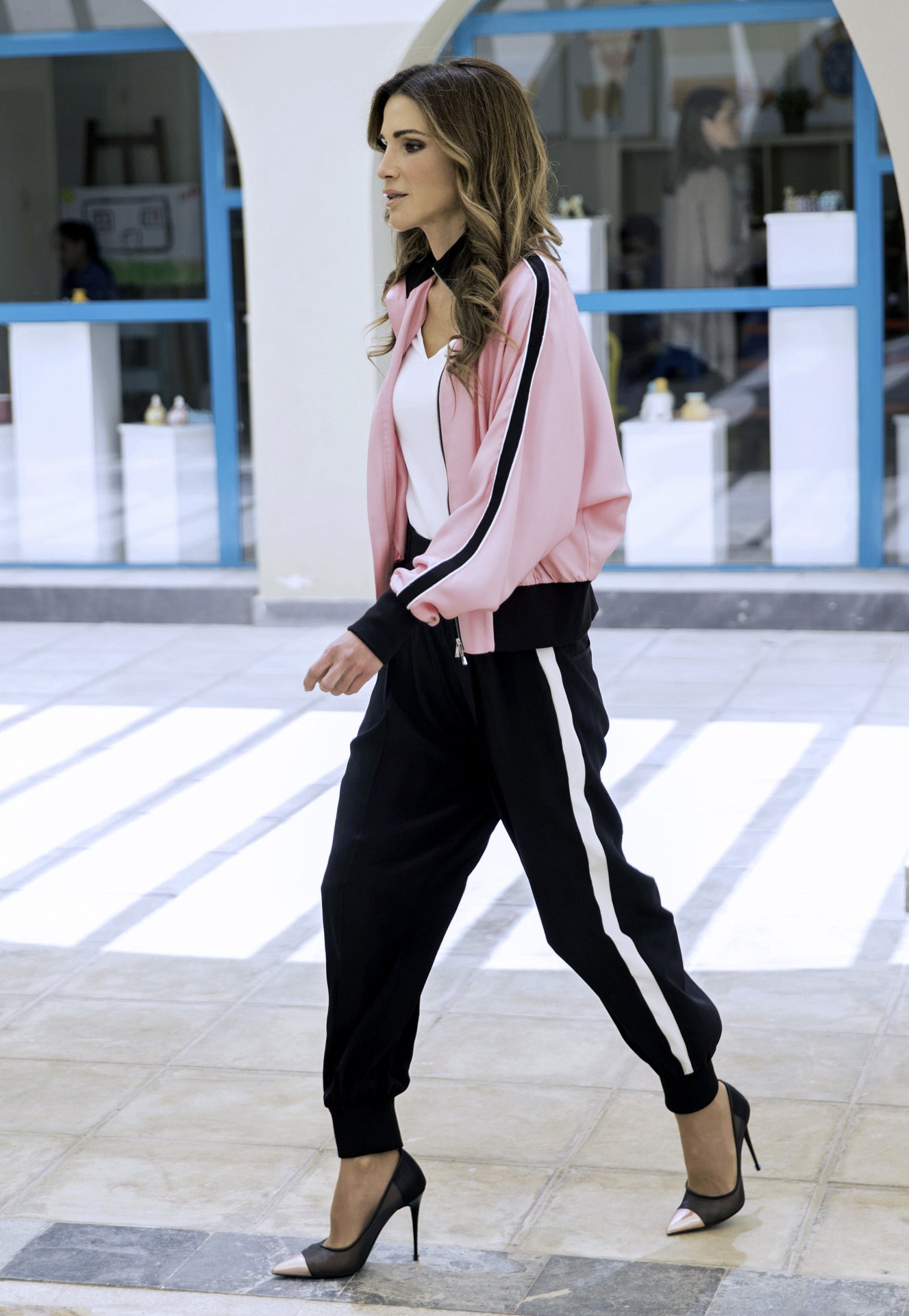 Y si sorprende ver cómo la monarca incorpora algunas tendencias, este look de chaqueta abierta y pantalón deportivo con salones, es digno de espectacularidad. Rania es capaz de lucir un chándal rosa y negro con unos zapatos de tacón en los mismos tonos al más puro estilo Kylie Jenner y vestir adecuada para actos como su visita al Centro de la Familia y el Niño en Jabal al Nasr.