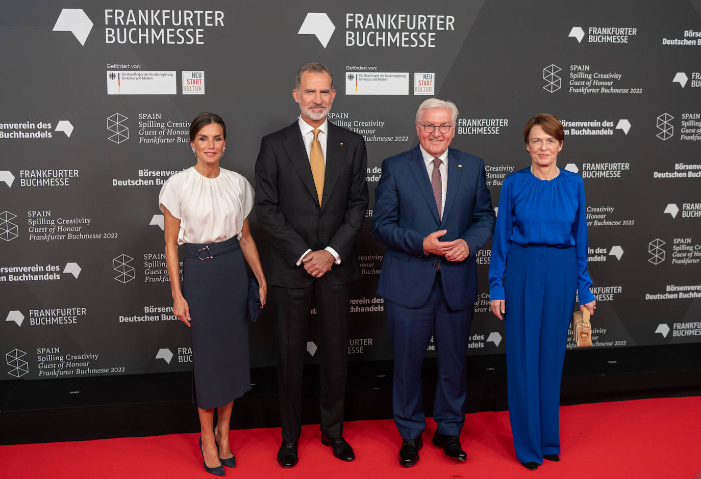 Tras dos días en Berlín, los Reyes viajaban a Franckfurt donde han inaugurado la Feria del Libro, en la que España es el país invitado.  Doña Letizia se decantaba por una falda de silueta lápiz en color azul marino y  una blusa blanca. Ambas piezas son de Hugo Boss. Lo ha combinado con stilettos y cartera de ante en azul marino. Doña Letizia volvía a recogerse el pelo, dejando así al descubierto los pendientes de zafiros y diamantes. Pertenecían a Doña Sofía, quién los llevó en numerosas ocasiones durante su reinado. 