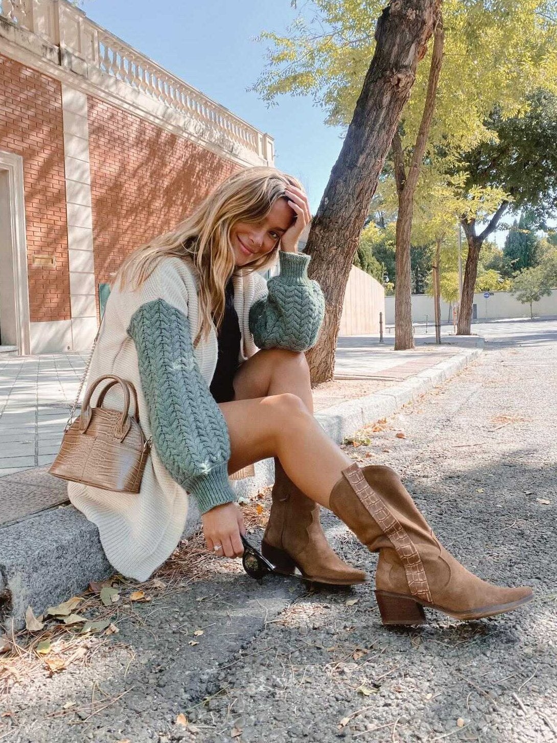 La empresaria e influencer María Pombo lleva botas cowboy de ante de Popa con un mini vestido y chaqueta.