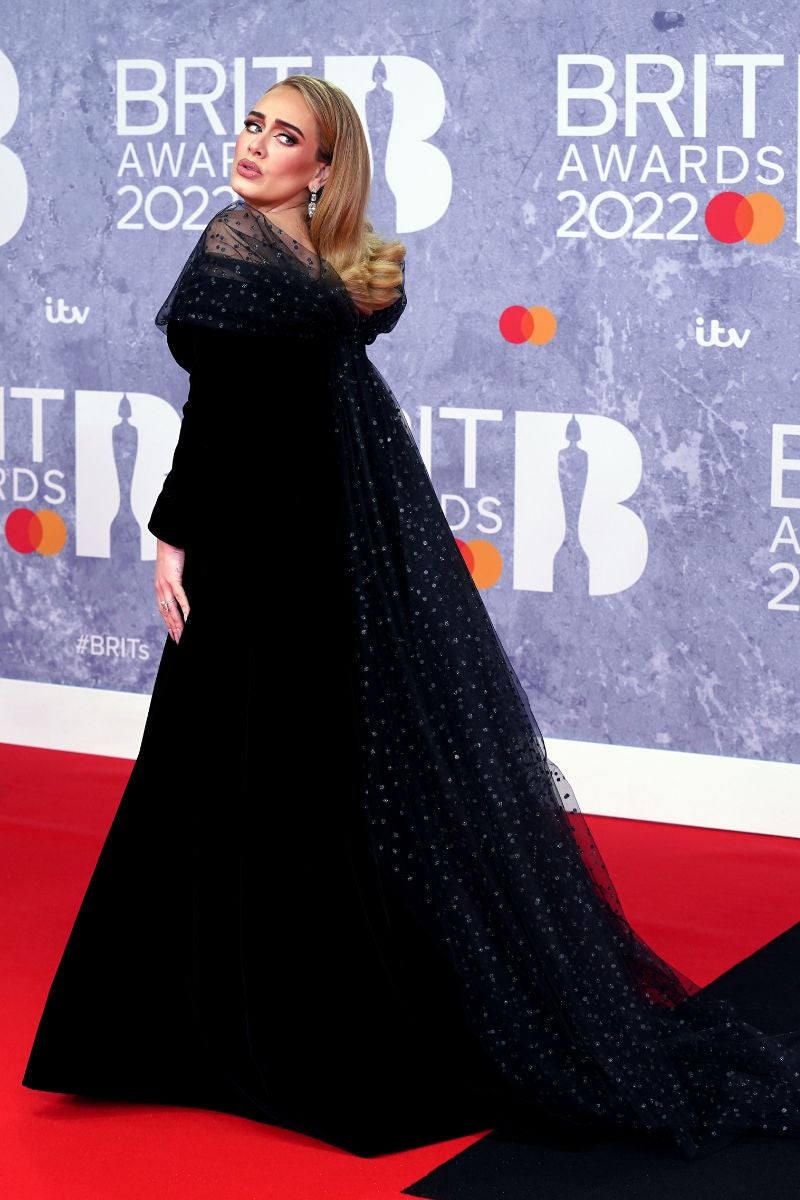 Adele en los Brit Awards 2022. La artista hizo su gran reaparición con una imagen completamente renovada fruto de diesta y ejercicio donde se hizo con todo el protagonismo gracias a un soberbio vestido negro de terciopelo de Armani Privé con escote Bardot y un lazo de gasa con topos que se prolongaba por la espalda y se fusionaba con la cola trasera.