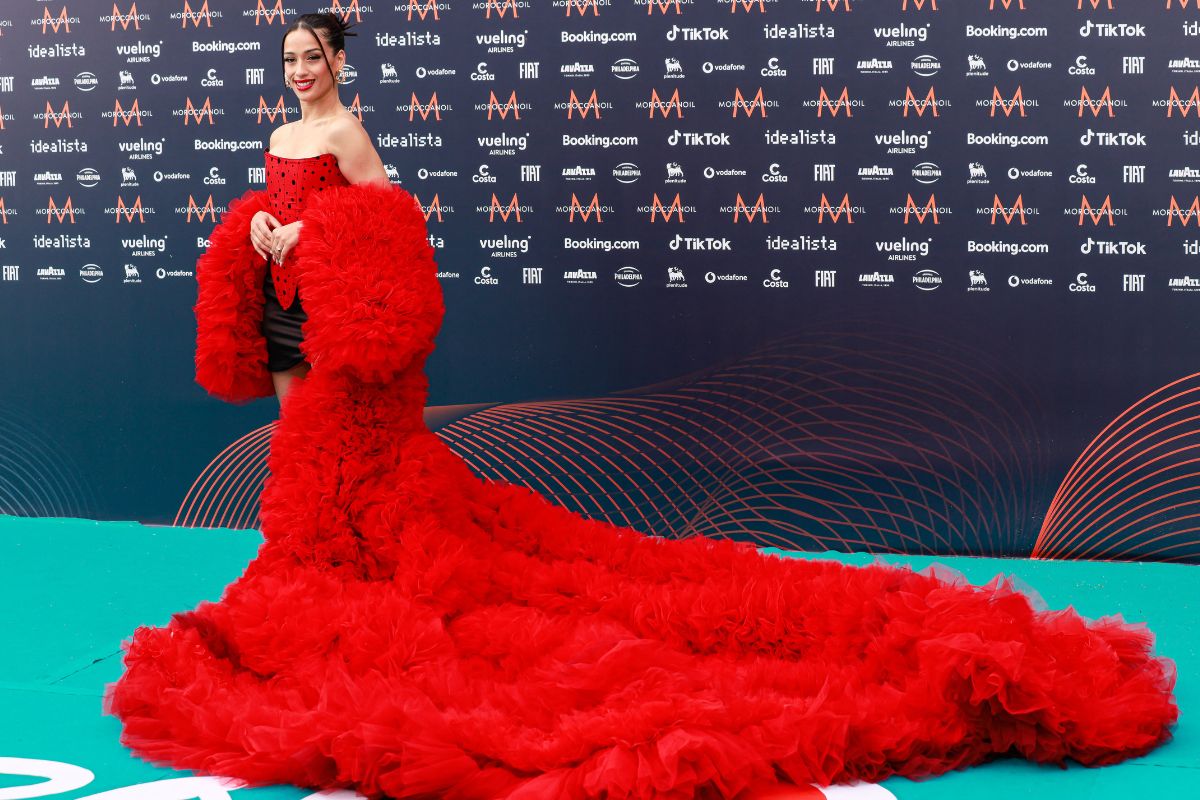 Chanel Terrero en la gala de apertura de Eurovisión. En la gala de apertura de Eurovisión (donde quedamos los segundos) la cantante lució un voluminoso vestido rojo cuyo corte recordaba a una bata de cola confeccionado en exclusiva para ella por Raúl Amor, director creativo de la firma It-Spain. pendientes de aro de Swarovski (el modelo Ortyx) y un recogido muy pulido con el que se convirtió en la protagonista.