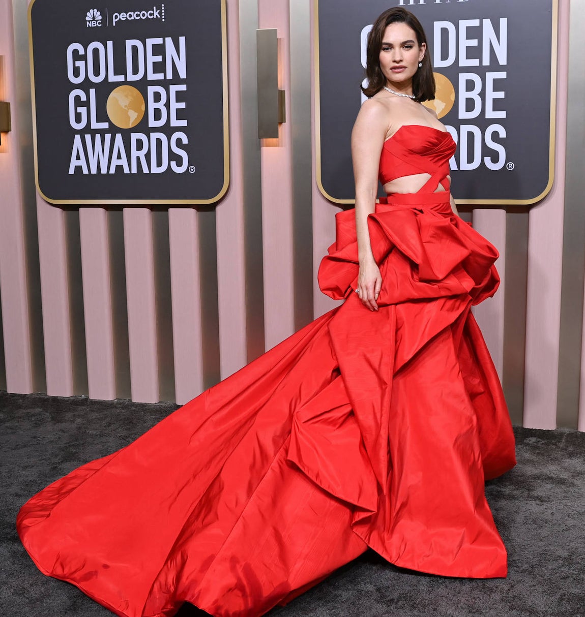 Lily James se decantó por un vistoso vestido de Versace, con volúmenes, escote palabra de honor y aberturas. Lo combinó con melena media suelta y un maquillaje elaborado por Nina Park con productos de Charlotte Tilbury, e inspirado en Audrey Hepburn. 