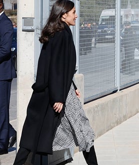 Imagen secundaria 2 - La reina con un estilismo muy elegante formado por abrigo negro, vestido con estampado Príncipe de Gales, y botas altas de ante. 