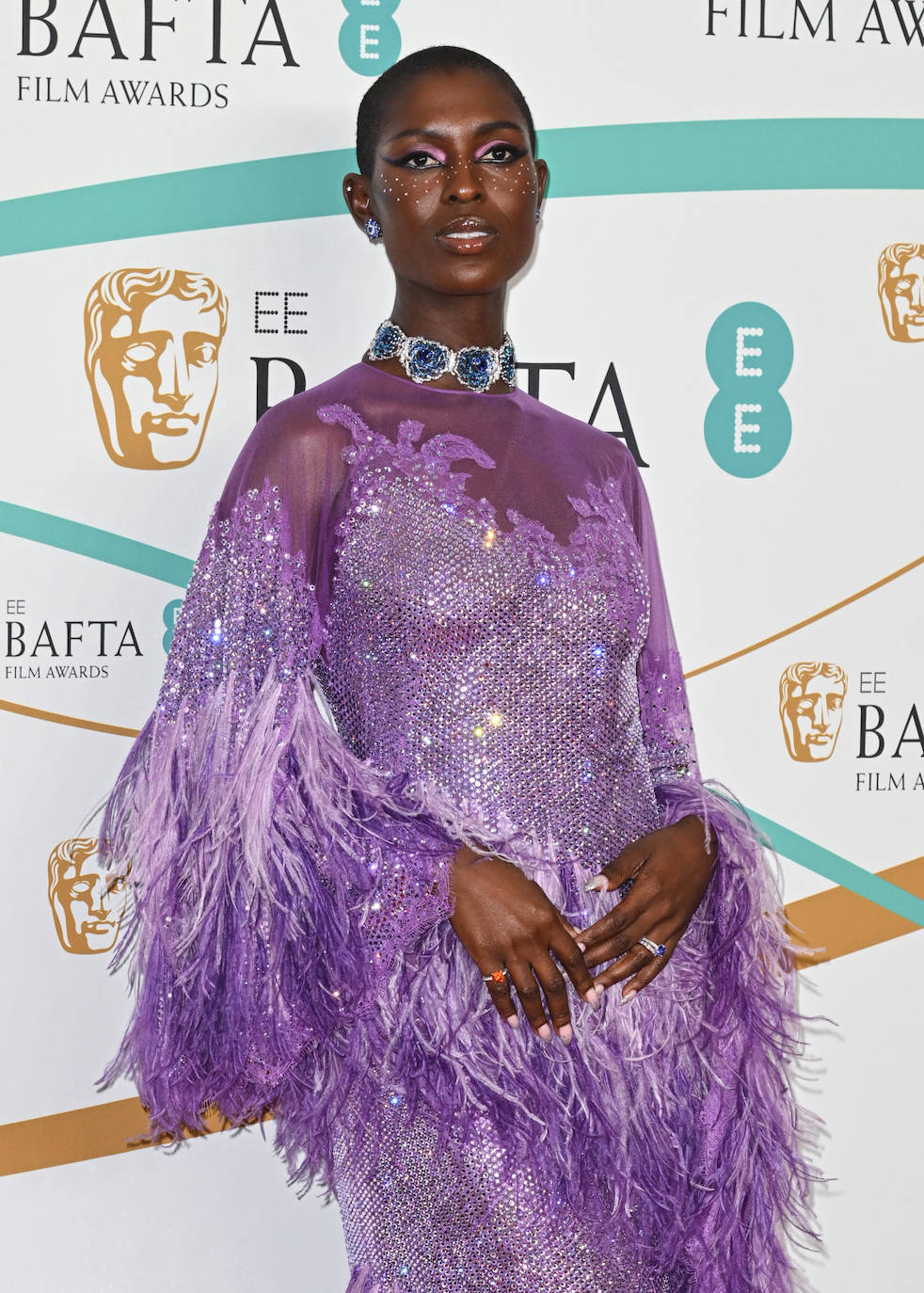 Jodie Turner-Smith lució un original vestido con plumas y lentejuelas en color malva de Gucci que combinó con un espectacular maquillaje de Charlotte Tilbury que incluía cristales en las mejillas. 