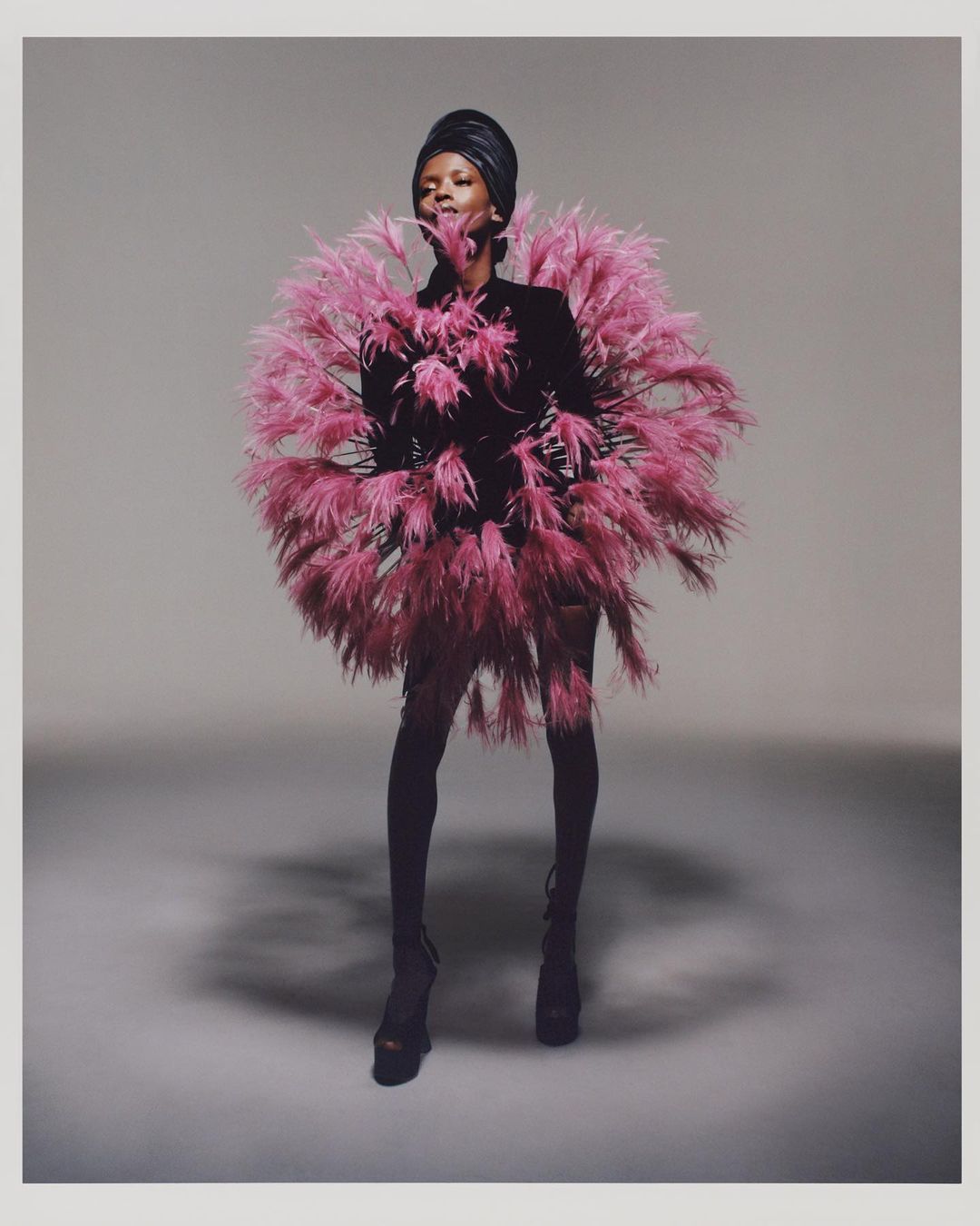 Este diseño lo describen en la web como 'Fuegos artificiales' en terciopelo negro bordado con plumas rosas. Turbante de terciopelo negro y botas.