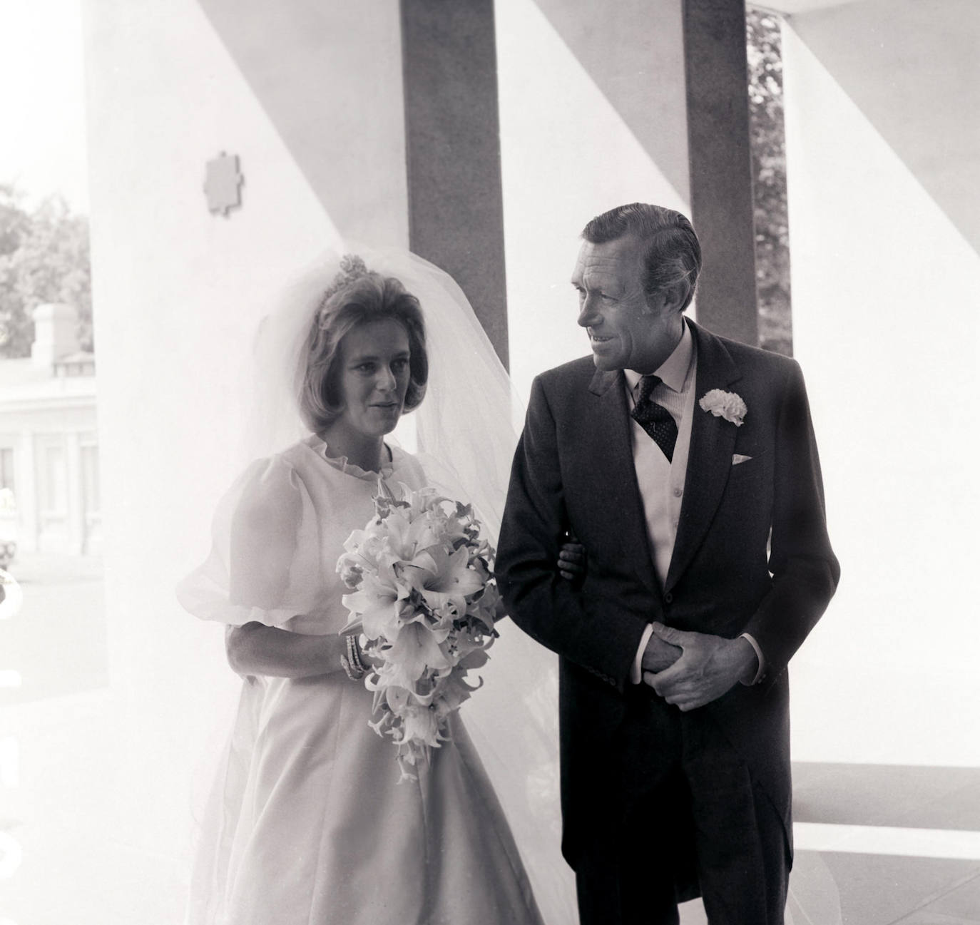 El 4 de julio de 1973 Camilla se casaba con Andrew Parker Bowles. Así fue su vestido de novia, sencillo y con velo. En la imagen junto a su padre. 