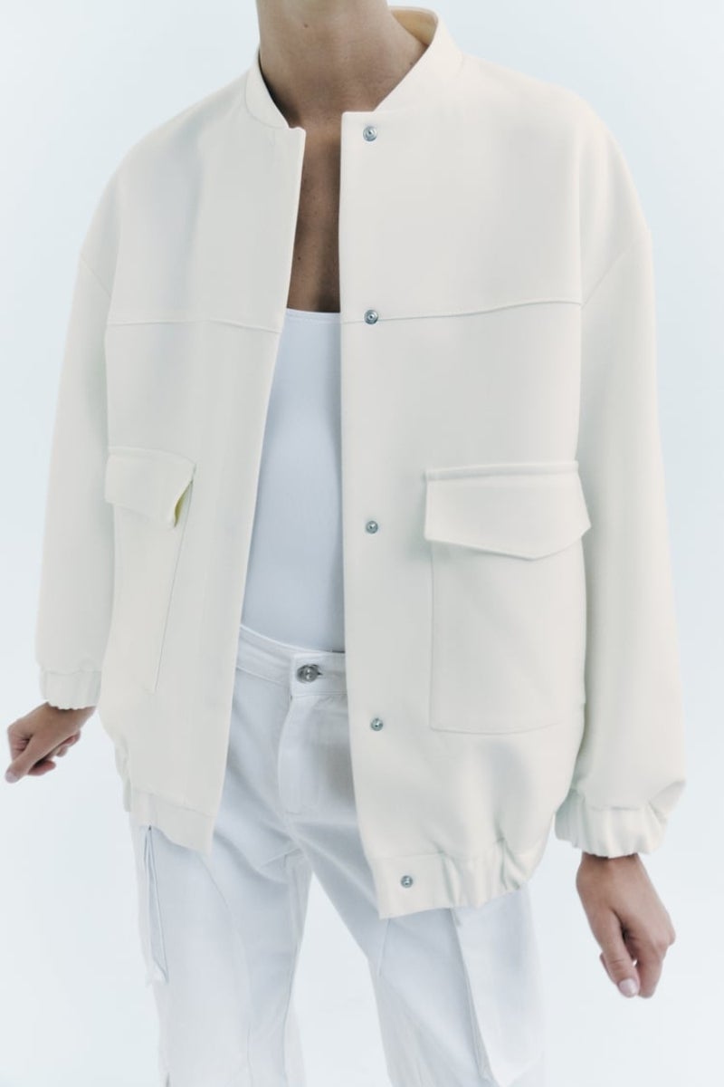 Bomber multibolsillos, de Zara. En color blanco, una de las tonalidades de la temporada, para completar hasta los estilismos más sencillos con un toque de tendencia. Posee manga larga, el cuello subido y bolsillos de plastrón con solapas. Precio: 49,95€.