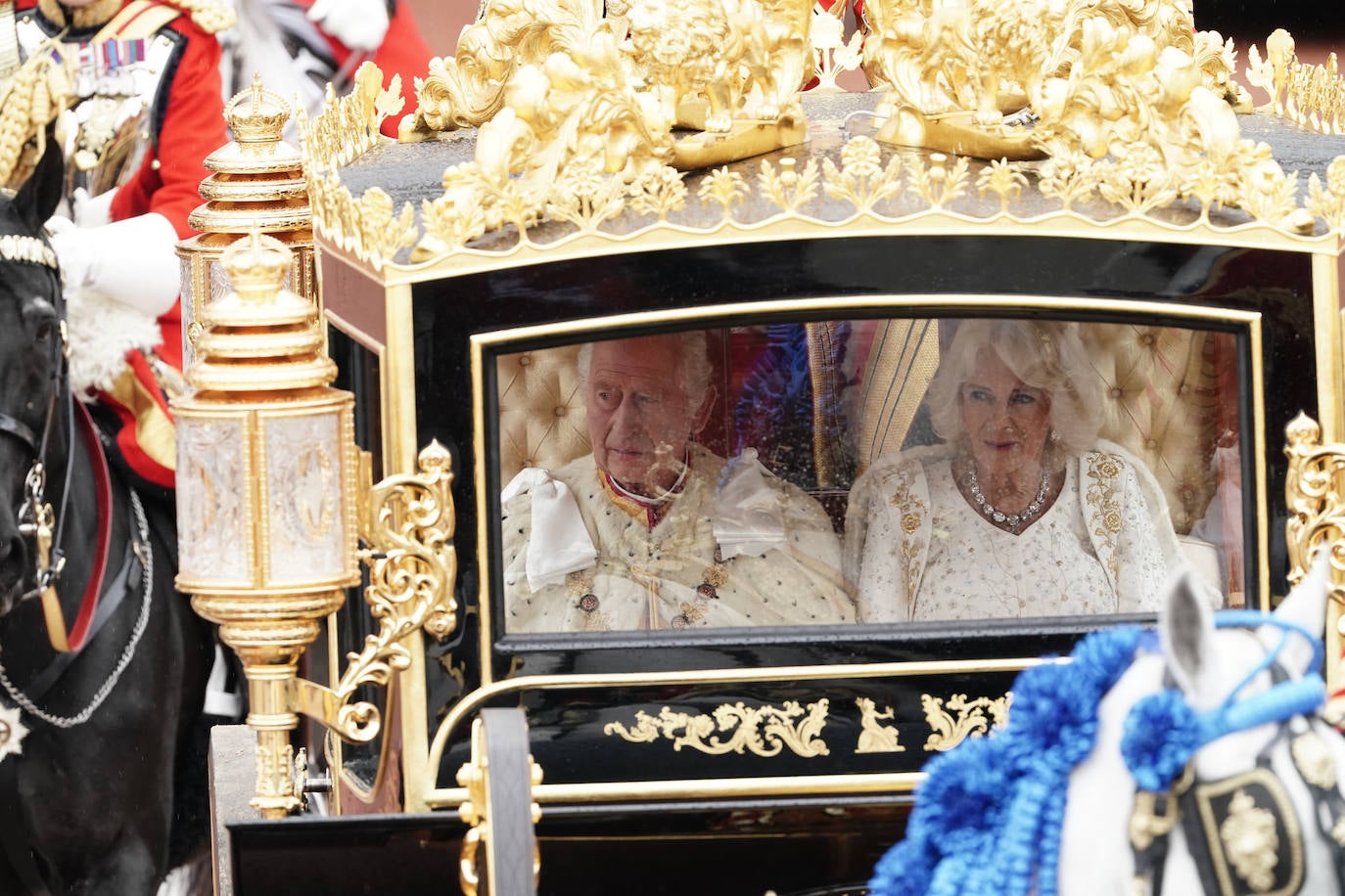 Carlos III y Camila, vestida de blanco con un vestido de alta costura diseñado por Bruce Oldfield. 