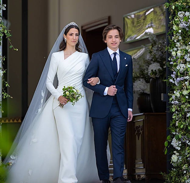 Rajwa al Saif ha lucido un elegante vestido con amplia cola. A la llegada a la ceremonia del brazo de uno de sus cuñados, hermano de su ya esposo.