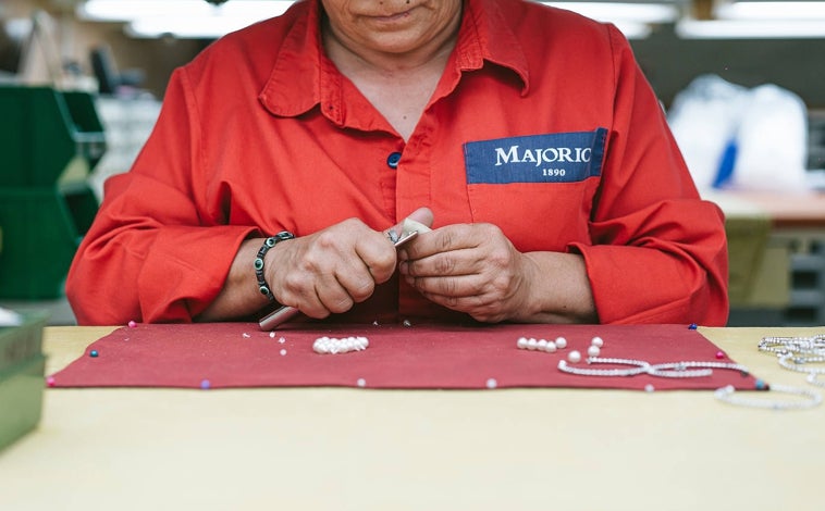 Imagen Principal - Los artesanos de Majorica trabajan en la fábrica de Manacor utilizando técnicas manuales para crear perlas orgánicas que replican perlas naturales.