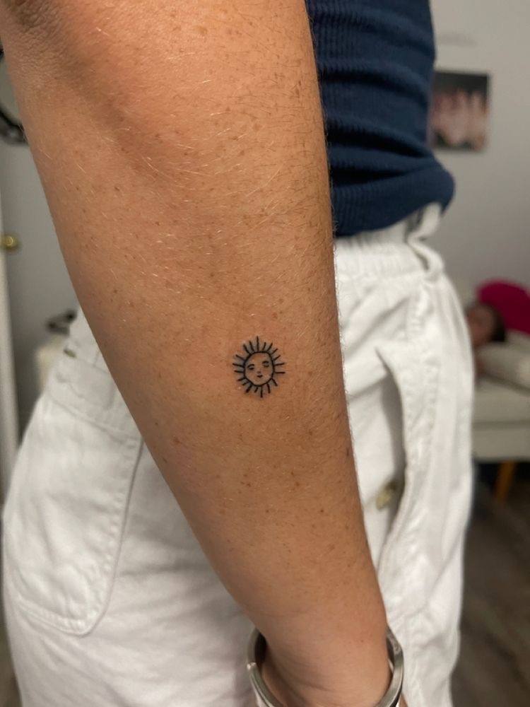Un 'minitattoo' de un sol en el brazo.