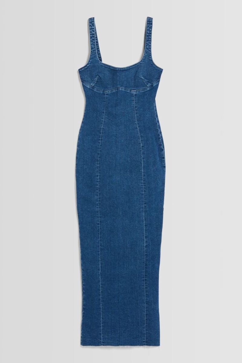 Bershka. Vestido denim largo, de corte ajustado, con tirantes y escote cuadrado con una abertura trasera XXL. Precio: 35,99€.
