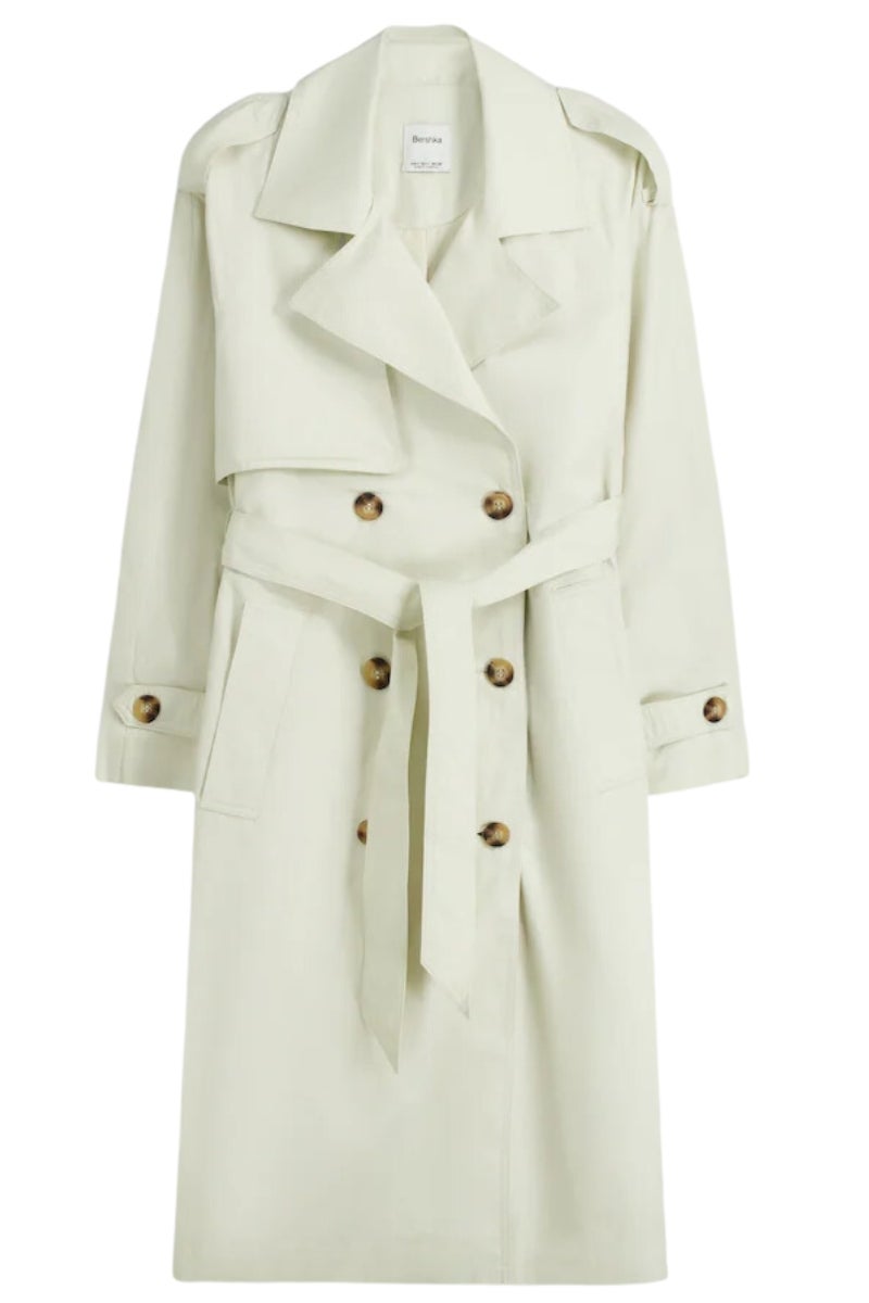 Bershka: trench de algodón fino en blanco roto con solapas cruzadas. El mejor aliado para los días lluviosos y gracias a su tejido fino proporcionará calidez en su justa medida. Precio: 39,99€.