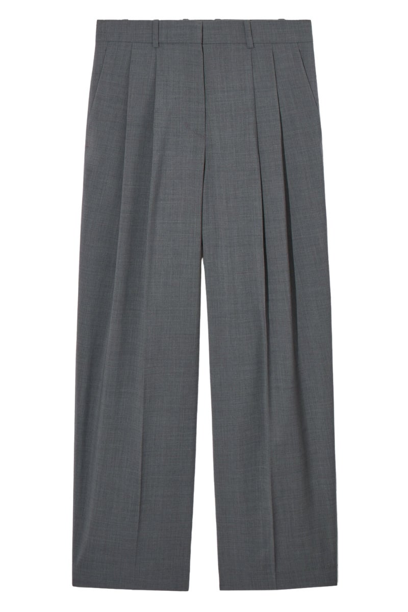 Cos: pantalones de sastre oversize en color gris con la cintura alta y pinzas en la pernera. Una opción que según cuenta la estilista se puede combinar con una camisa XXL blanca por fuera y unas sandalias para una jornada de oficina que termine en un afterwork. Precio: 125€.