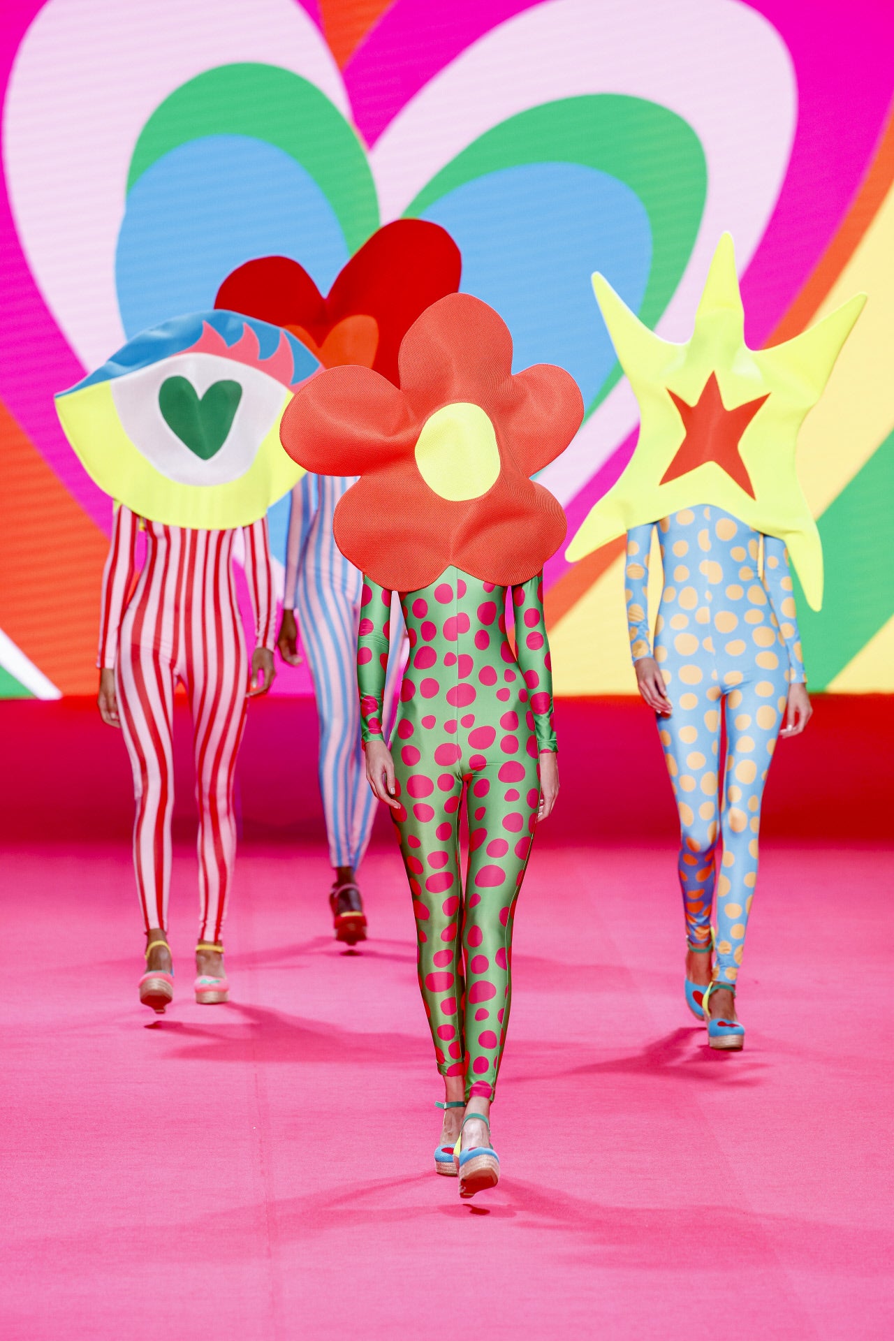 Desfile de Ágatha Ruiz de la Prada en la MBFWMadrid primavera-verano 2024. Uno de los momentos más divertidos del desfile, cuando varias modelos salieron a lucir diferentes monos ajustados sin mostrar sus cabezas, tapadas por estas formas gigantes.