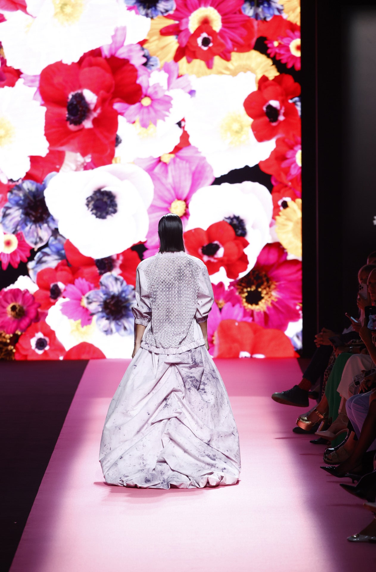 La pasarela ha estado presidida por un mural plagado de flores de colores. 