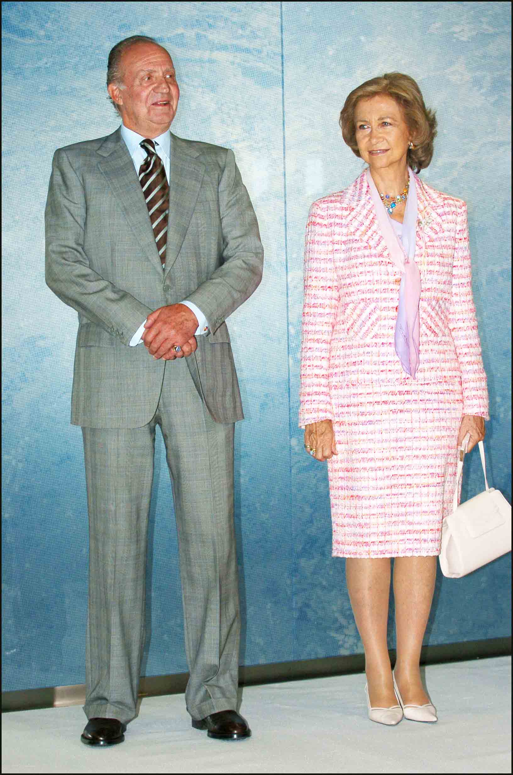 En esta imagen, junto a Juan Carlos I, aparece con un traje de chaqueta y falda, confeccionado en tweed en tonos rosas y blancos. Lo decoró con un pañuelo en la zona del escote. 