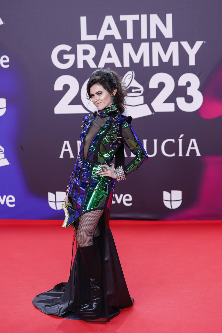 Minivestido galáctico con capa y combinado con botas altas, una calzado que no es el más indicado para un alfombra roja. 