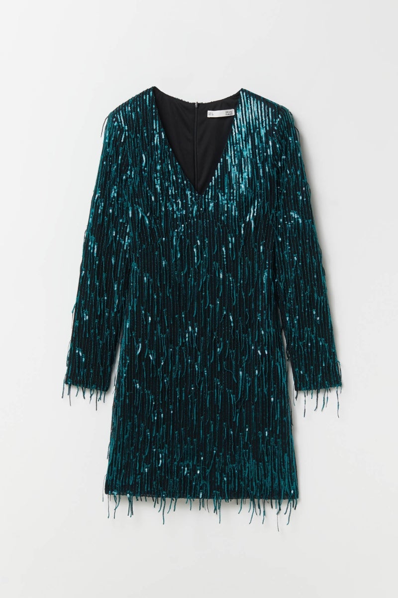 Sfera. Vestido verde botella con flecos y lentejuelas, escote en uve y minifalda. Precio: 35,99€.