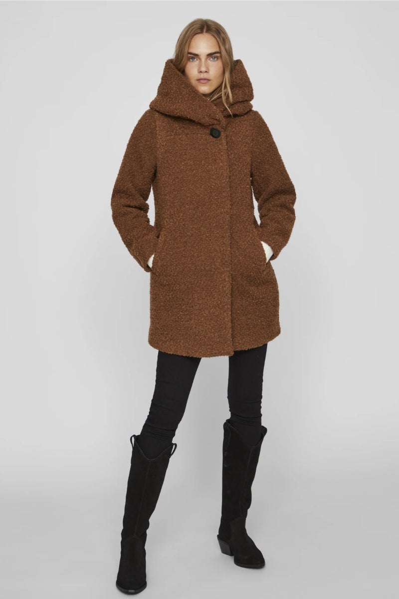 Vila para Zalando. Abrigo de borrego sintético con capucha y un gran botón de gran tamaño que hace de cierre. Precio: 119,99€.