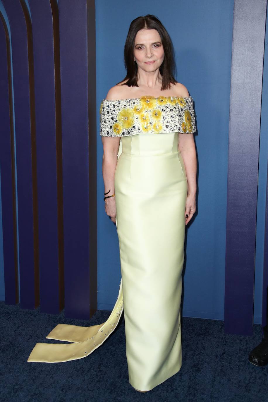 Juliette Binoche con un sofisticado diseño en color amarillo con detalle floral en la parte superior. 