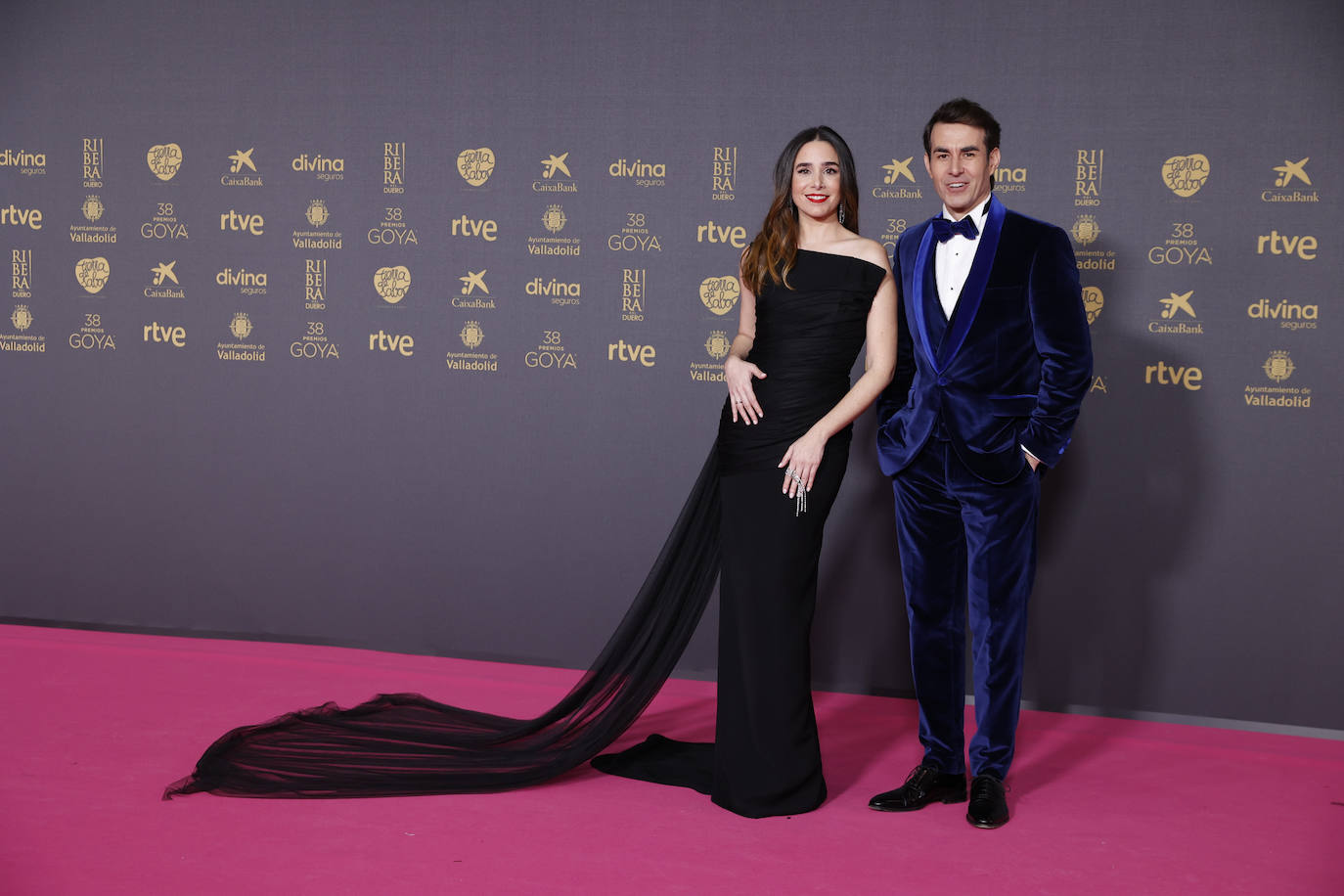 Candela Serrat, que posó con su pareja, Daniel Muriel, eligió un vestido negro con cola de Luis Berrendero, con joyas de Messika, zapatos de tacón de Martinelli y maquillaje de Maria Nebrera con Lancôme.