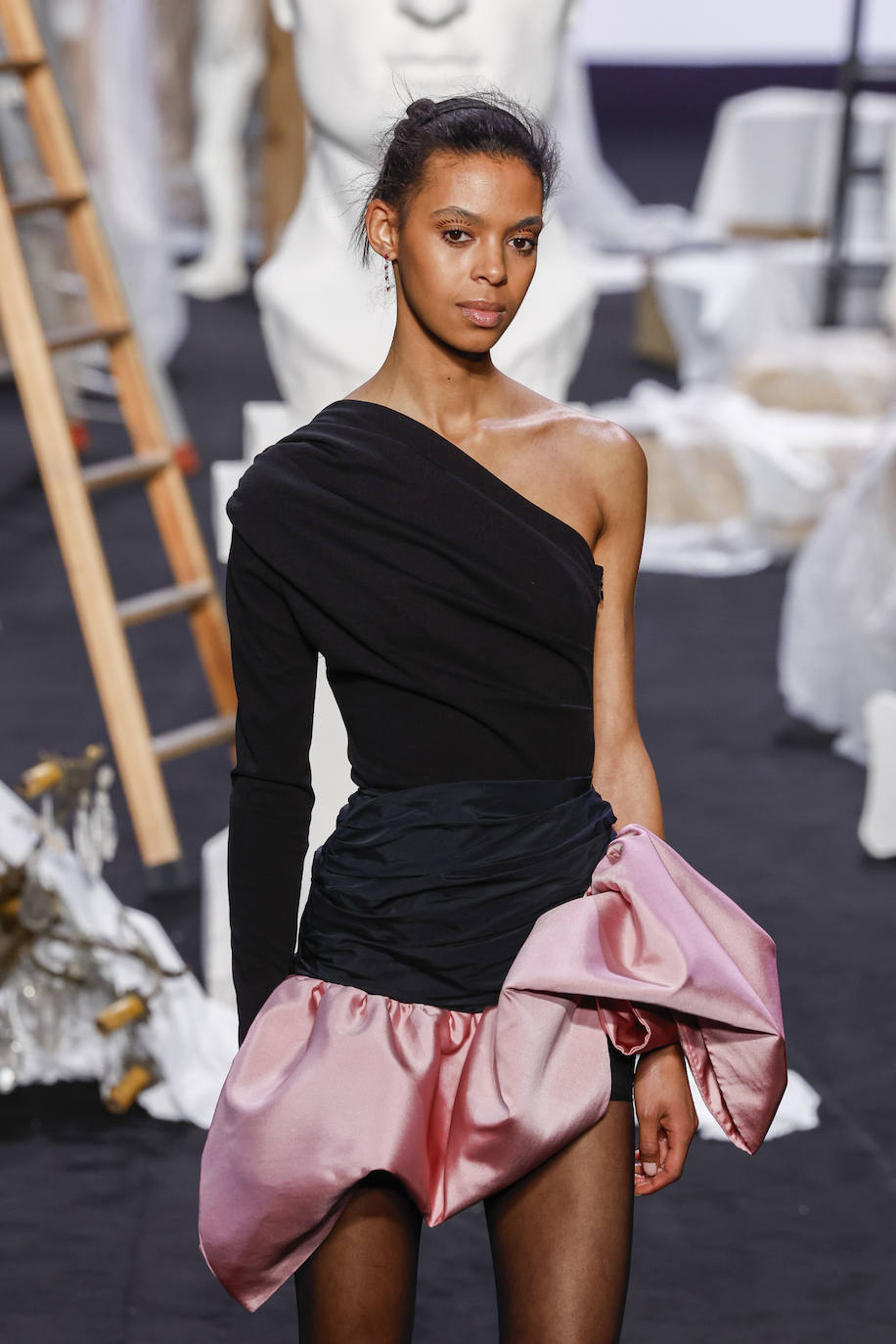 Vestido asimétrico con una manga larga y bajo rosa con volumen. 