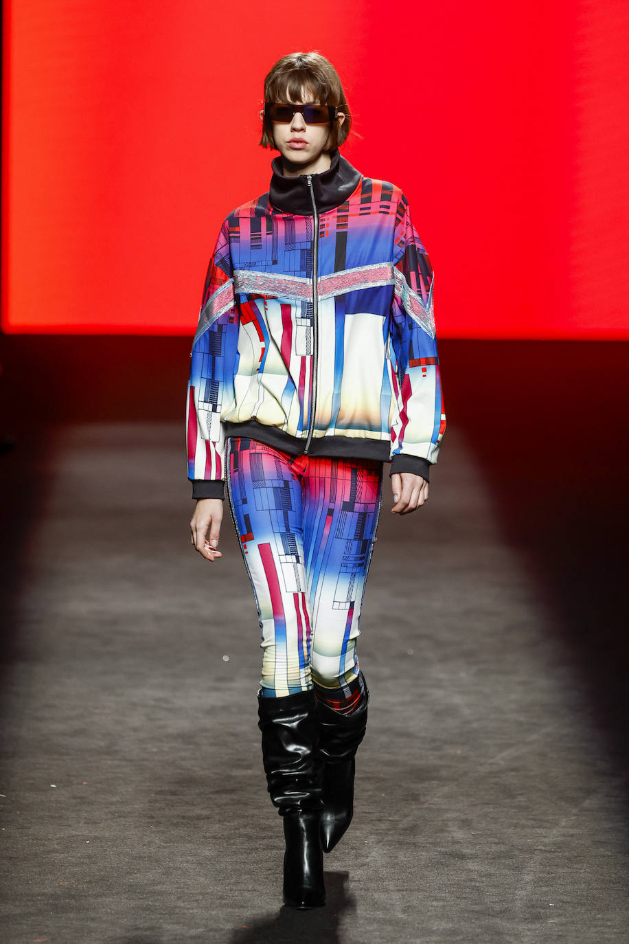 Una paleta de colores vibrantes y elementos gráficos refuerzan la experiencia visual en el desfile, creando un ambiente distintivo.