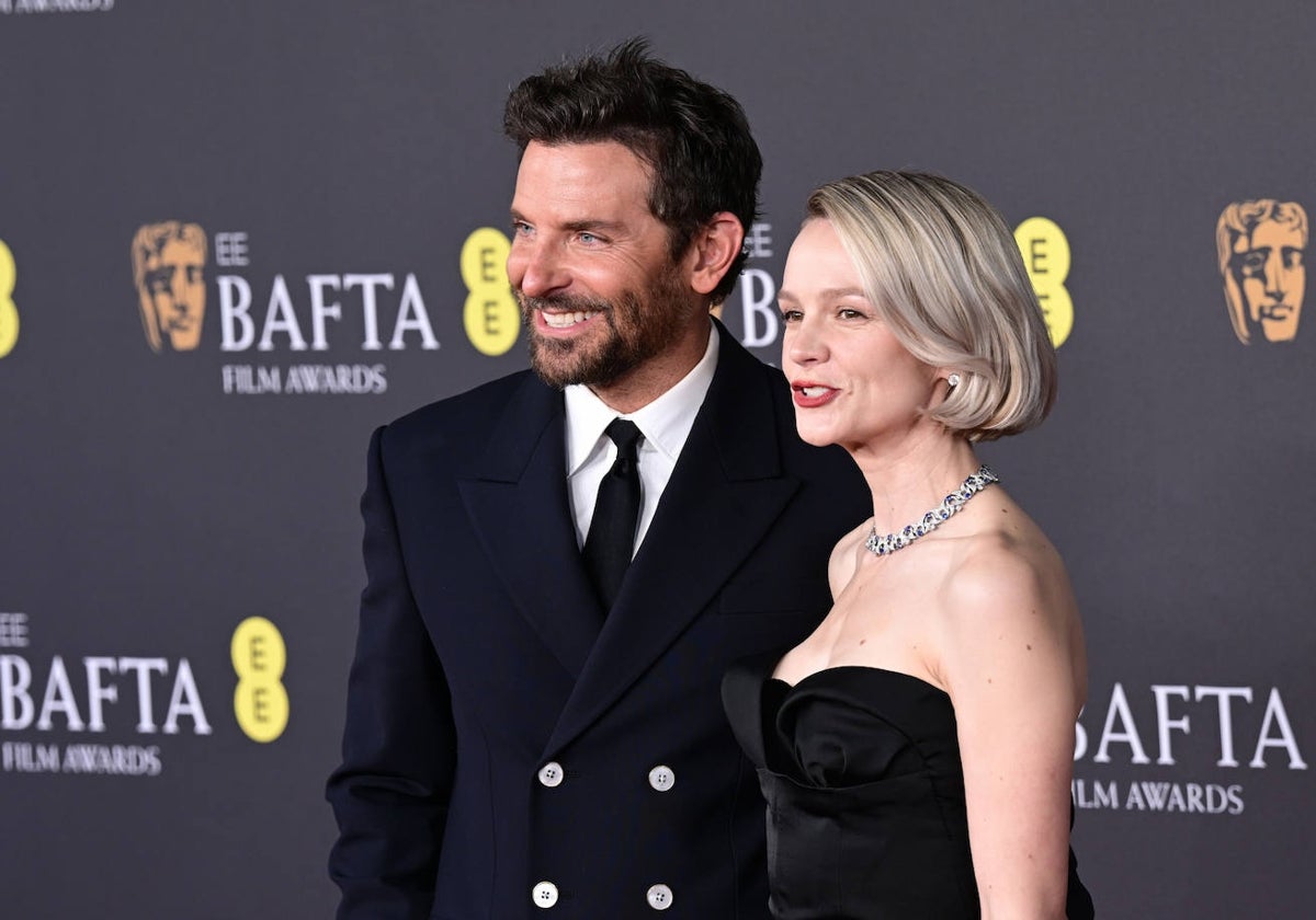 Bradley Cooper, con abrigo tres cuartos, y Carey Mulligan, con vestido negro, en la alfombra roja de los Bafta.