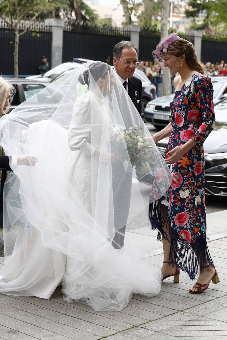 Victoria López-Quesada y de Borbón-Dos Sicilias con vestido estilo mantón de Manila de escote asimétrico con fondo azul y bordados florales, ha sido además una de las encargadas de ayudar a la novia en su llegada a la iglesia. 