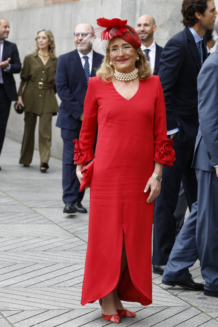 Casilda Martínez-Almeida, hermana mayor del novio y madrina de la boda, escogió con vestido rojo y tocado en el mismo color. Se trata de un diseño largo con escote en V, abertura central y mangas rematadas en flor de la firma Navascués, la misma que retocó en sus talleres el vestido de la novia.