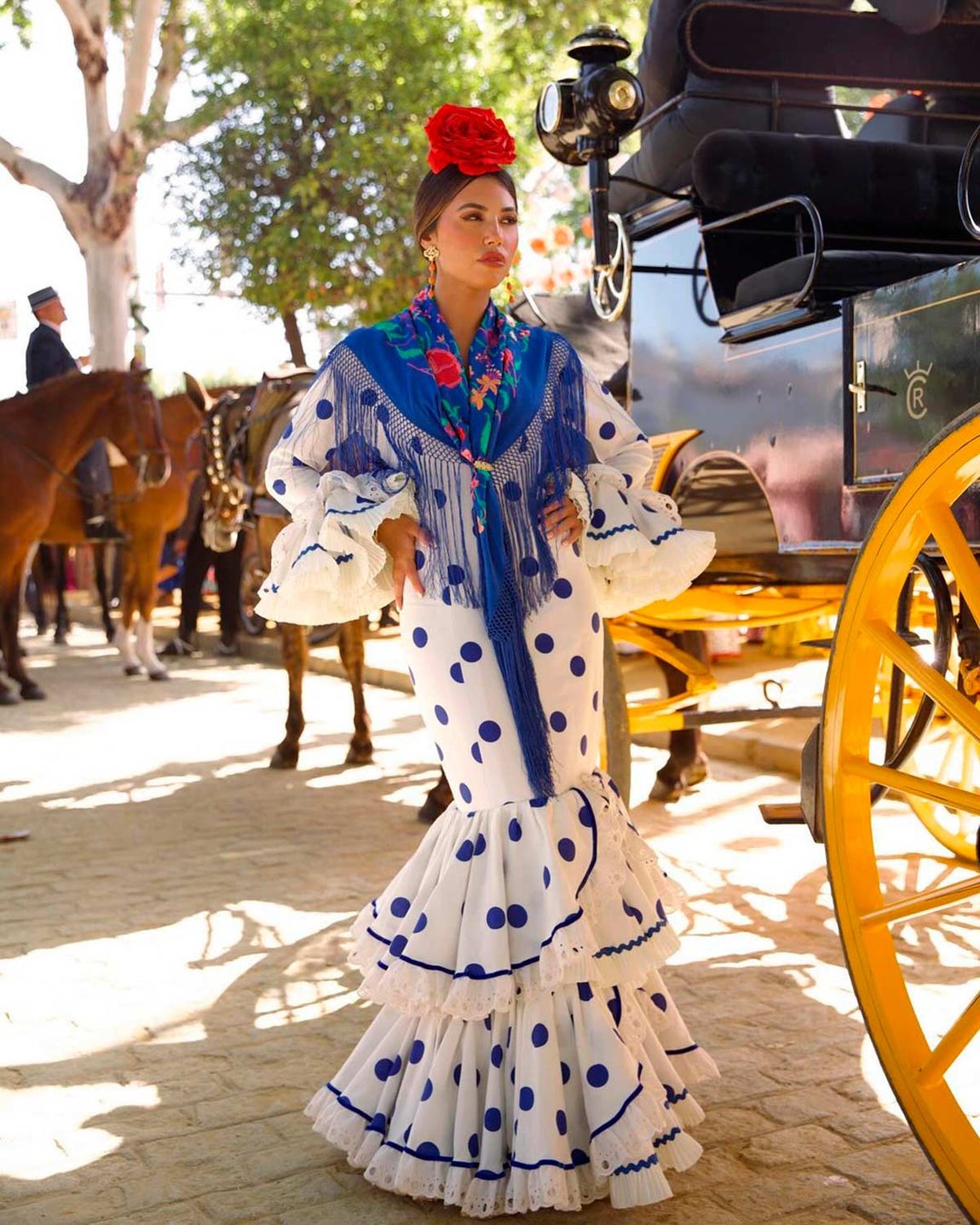 La sevillana María Segarra combinó a la perfección el blanco con el azul y el rojo con este diseño de lunares. Firmado por Rocio Peralta presenta una silueta entallada y encaje en los volantes. Llevó una flor roja en el pelo y joyas de Lojo. 