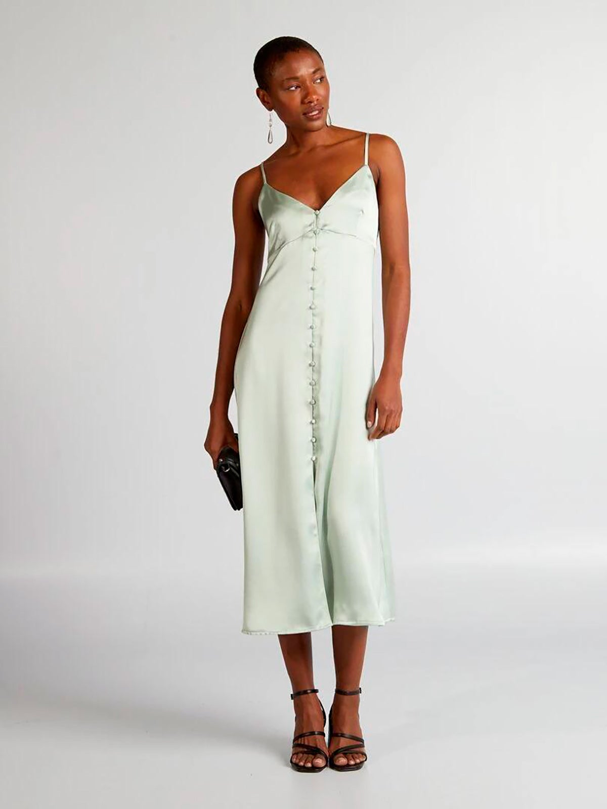 Vestido satinado en color verde agua, con cierre de botones, tirantes finos y corte midi. 32 euros en Kiabi.