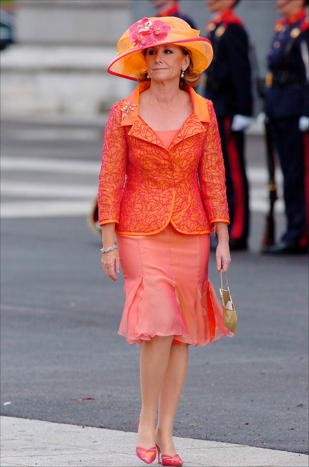 Esperanza Aguirre no se perdió la boda de los Reyes de España. Lució un look en tonos naranjas compuesto por un vestido cóctel con un minivolante en el bajo y una chaqueta a juego. También llevó una pamela. 